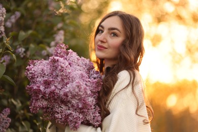 Photo of Beautiful woman with bouquet of lilac flowers outdoors in morning