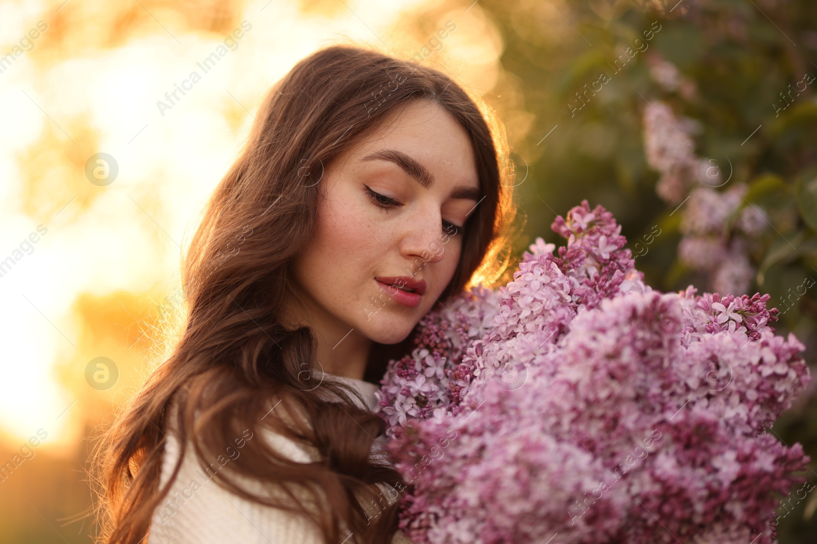 Beautiful woman with bouquet of lilac flowers outdoors in morning, closeup Photo of Beautiful woman with bouquet of lilac flowers outdoors in morning, closeup