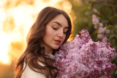 Photo of Beautiful woman with bouquet of lilac flowers outdoors in morning, closeup
