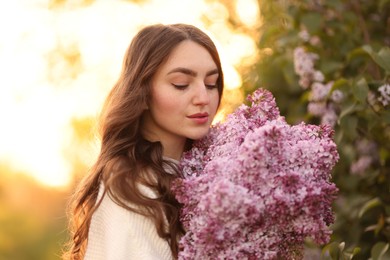 Photo of Beautiful woman with bouquet of lilac flowers outdoors in morning, closeup