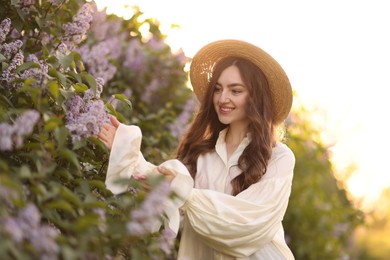 Photo of Smiling woman and beautiful lilac bush in morning