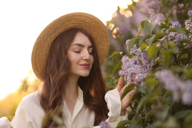 Photo of Beautiful woman and lilac bush in morning, closeup