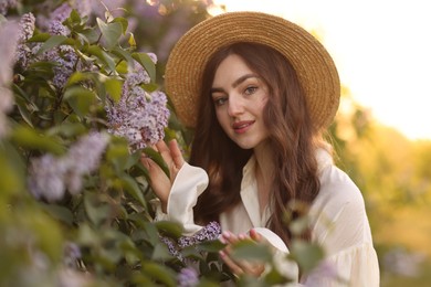 Photo of Portrait of smiling woman and lilac bush outdoors in morning