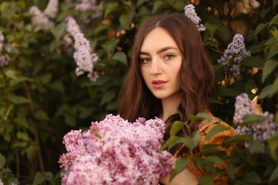 Photo of Portrait of beautiful woman with lilac flowers near bush outdoors