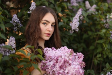 Photo of Portrait of beautiful woman with lilac flowers near bush outdoors