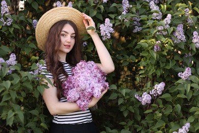 Photo of Beautiful woman among lilac flowers and leaves outdoors