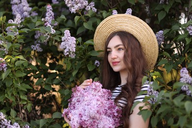 Photo of Beautiful woman among lilac flowers and leaves outdoors