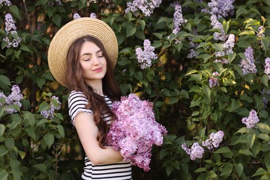 Photo of Beautiful woman among lilac flowers and leaves outdoors