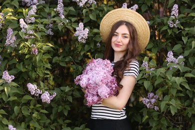 Photo of Beautiful woman among lilac flowers and leaves outdoors