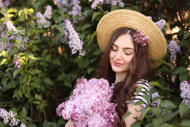 Photo of Beautiful woman among lilac flowers and leaves outdoors