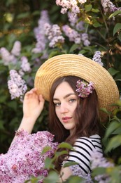 Photo of Beautiful woman among lilac flowers and leaves outdoors