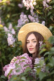 Photo of Beautiful woman among lilac flowers and leaves outdoors