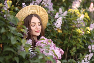 Photo of Beautiful woman among lilac flowers and leaves outdoors
