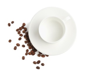 Photo of Ceramic cup with roasted coffee beans isolated on white, top view