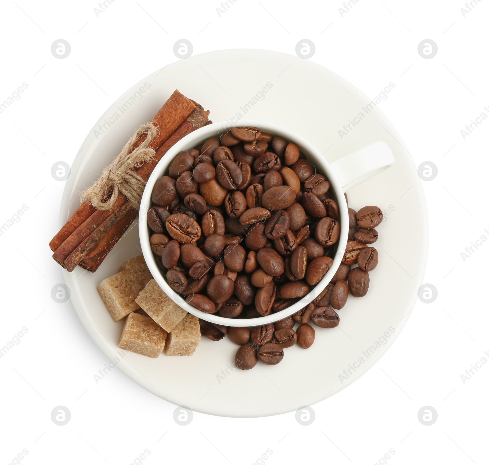 Ceramic cup with roasted coffee beans, sugar and cinnamon isolated on white, top view Photo of Ceramic cup with roasted coffee beans, sugar and cinnamon isolated on white, top view