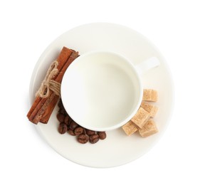 Photo of Ceramic cup with roasted coffee beans, sugar and cinnamon isolated on white, top view