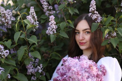Photo of Beautiful woman among lilac flowers and leaves outdoors