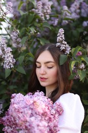 Photo of Beautiful woman among lilac flowers and leaves outdoors