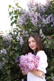 Photo of Beautiful woman among lilac flowers and leaves outdoors