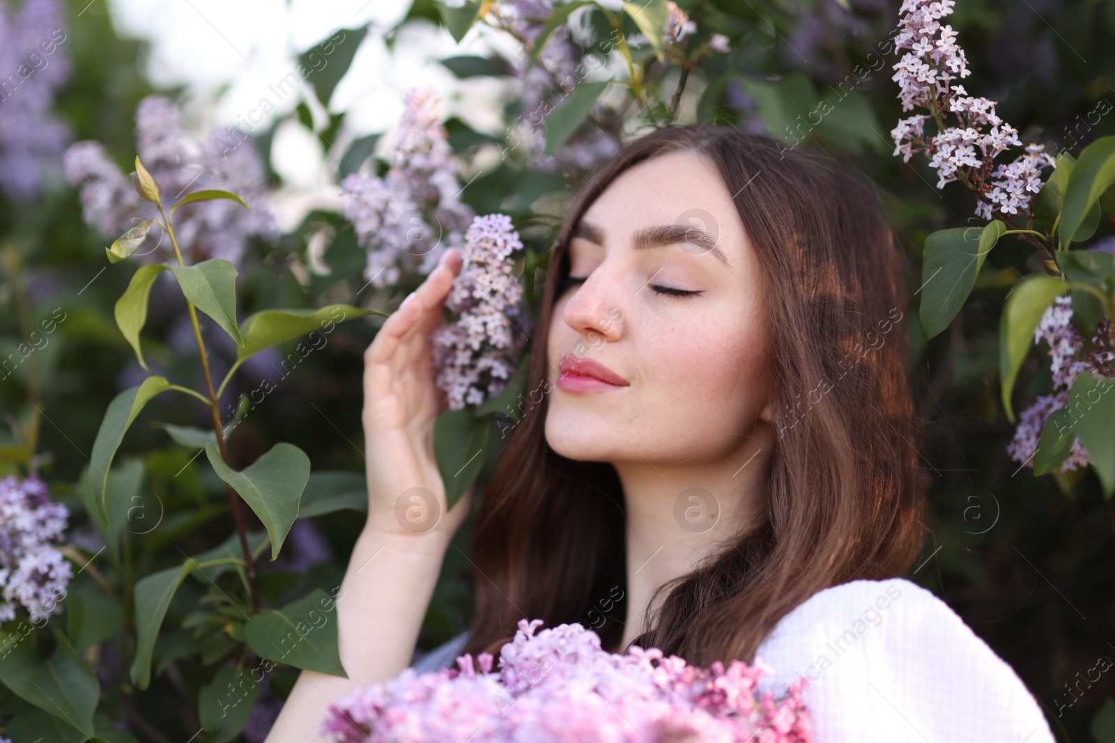 Beautiful woman among lilac flowers and leaves outdoors, closeup Photo of Beautiful woman among lilac flowers and leaves outdoors, closeup