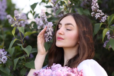 Photo of Beautiful woman among lilac flowers and leaves outdoors, closeup