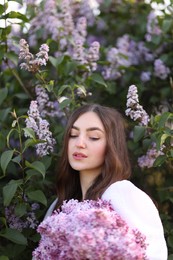Photo of Beautiful woman among lilac flowers and leaves outdoors