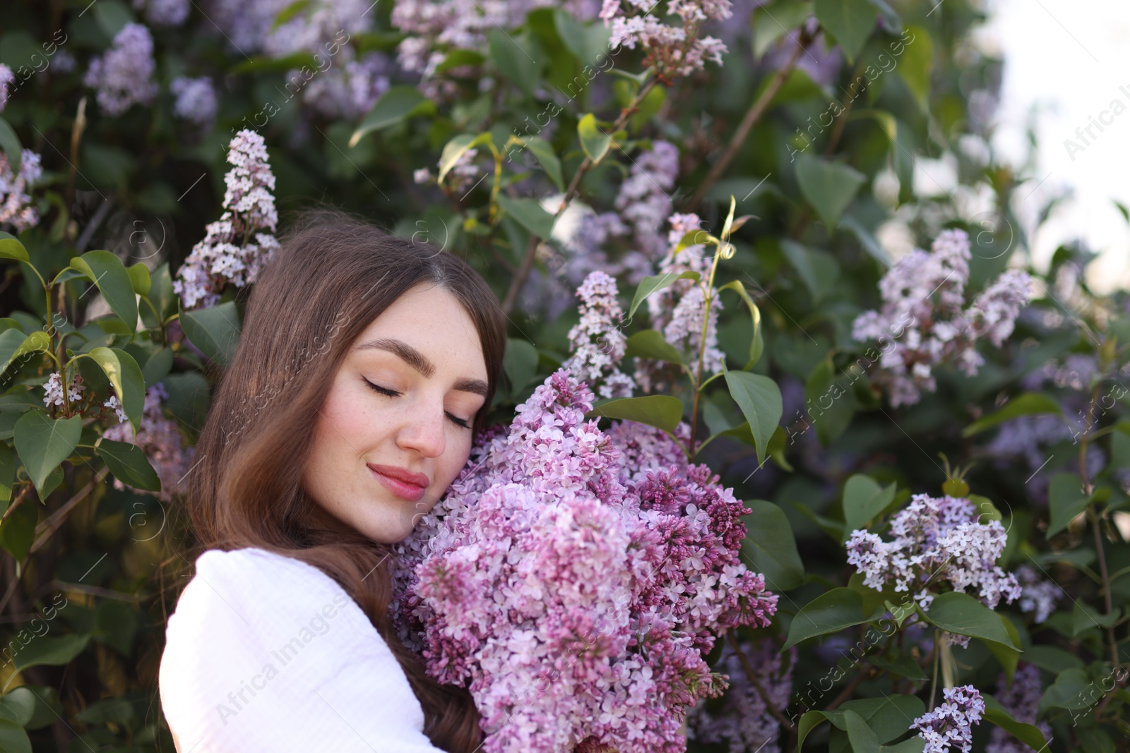 Beautiful woman among lilac flowers and leaves outdoors, closeup Photo of Beautiful woman among lilac flowers and leaves outdoors, closeup