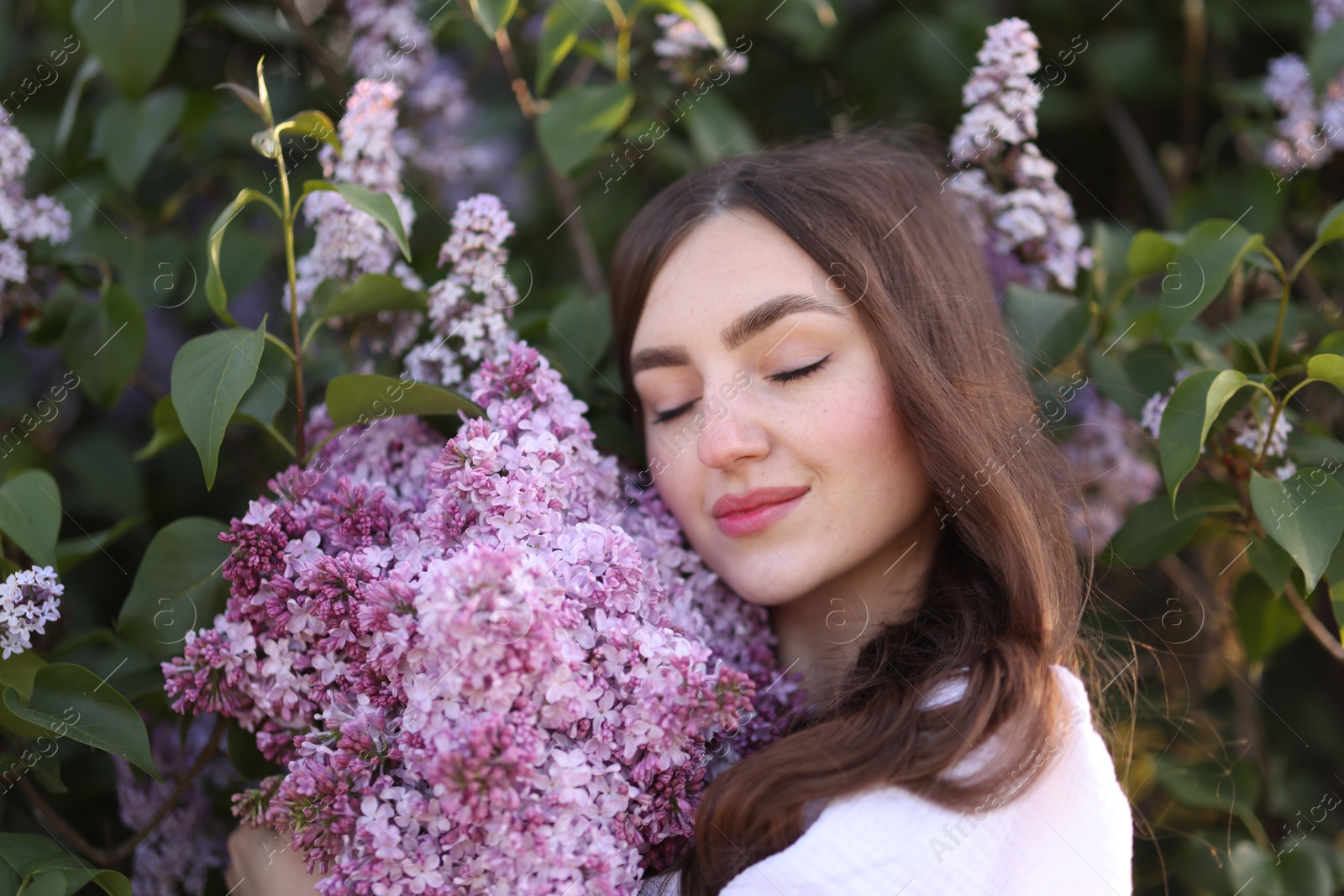 Beautiful woman among lilac flowers and leaves outdoors, closeup Photo of Beautiful woman among lilac flowers and leaves outdoors, closeup