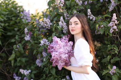 Photo of Beautiful woman among lilac flowers and leaves outdoors