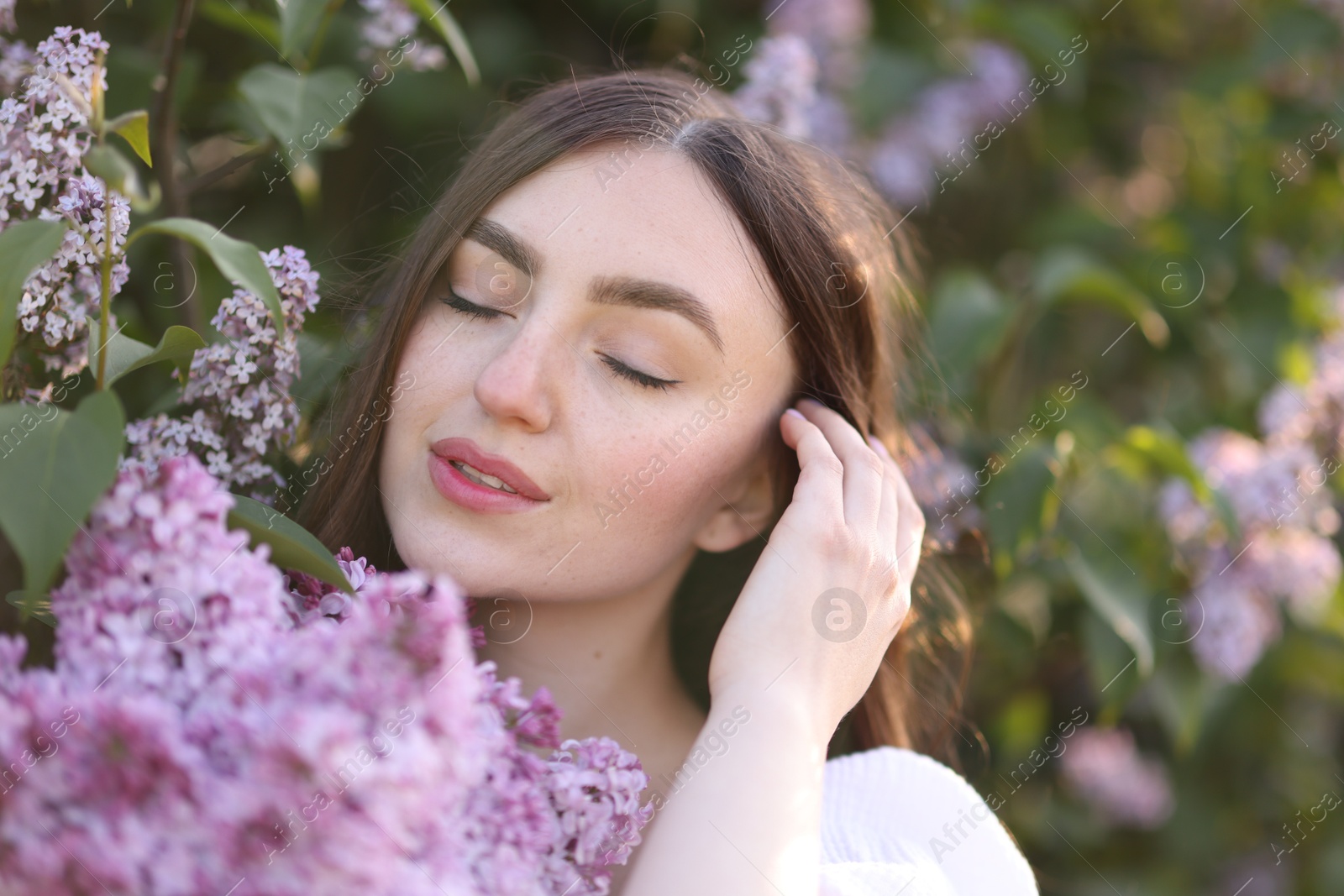 Beautiful woman among lilac flowers and leaves outdoors, closeup Photo of Beautiful woman among lilac flowers and leaves outdoors, closeup