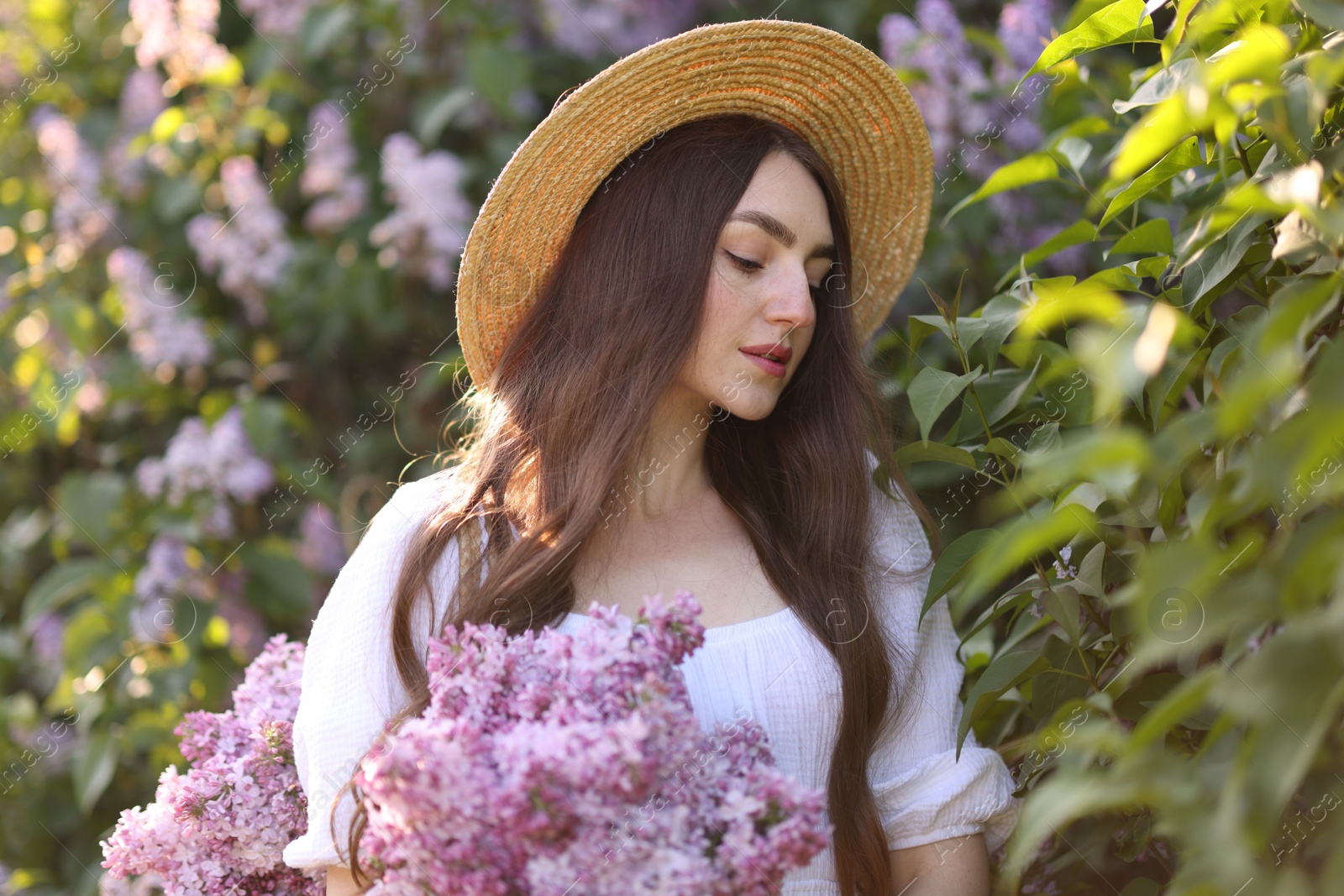 Beautiful woman among lilac flowers and leaves outdoors Photo of Beautiful woman among lilac flowers and leaves outdoors