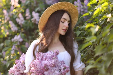 Photo of Beautiful woman among lilac flowers and leaves outdoors