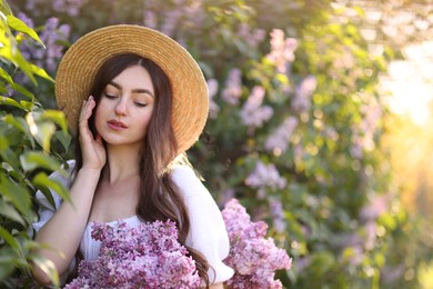 Photo of Beautiful woman among lilac flowers and leaves outdoors in morning. Space for text