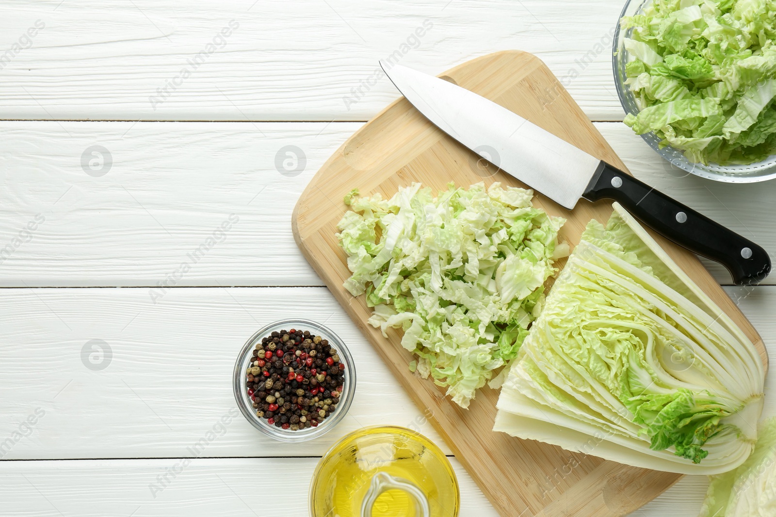 Photo of Cut Chinese cabbage and knife on white wooden table, flat lay. Space for text