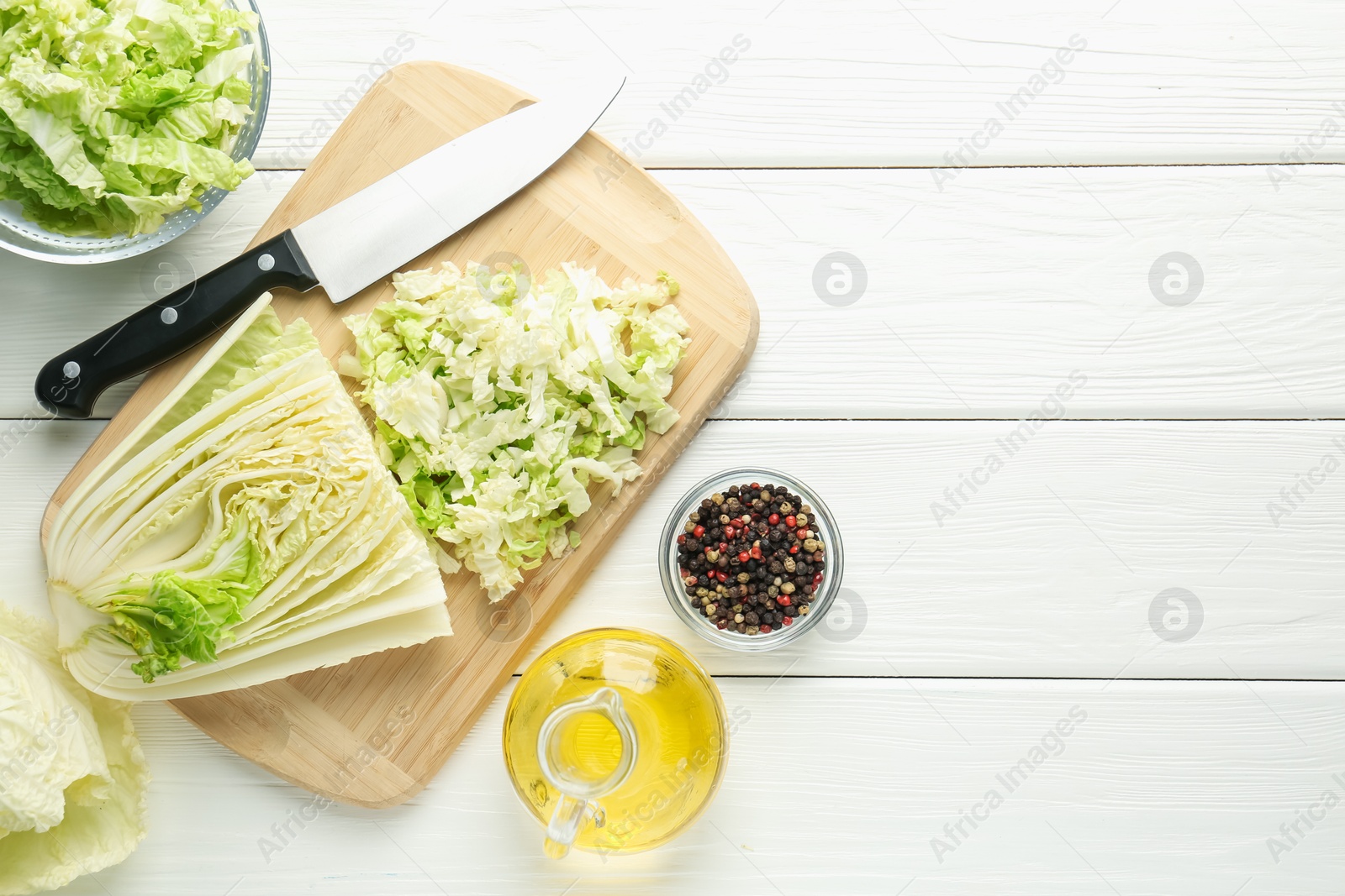 Photo of Cut Chinese cabbage and knife on white wooden table, flat lay. Space for text