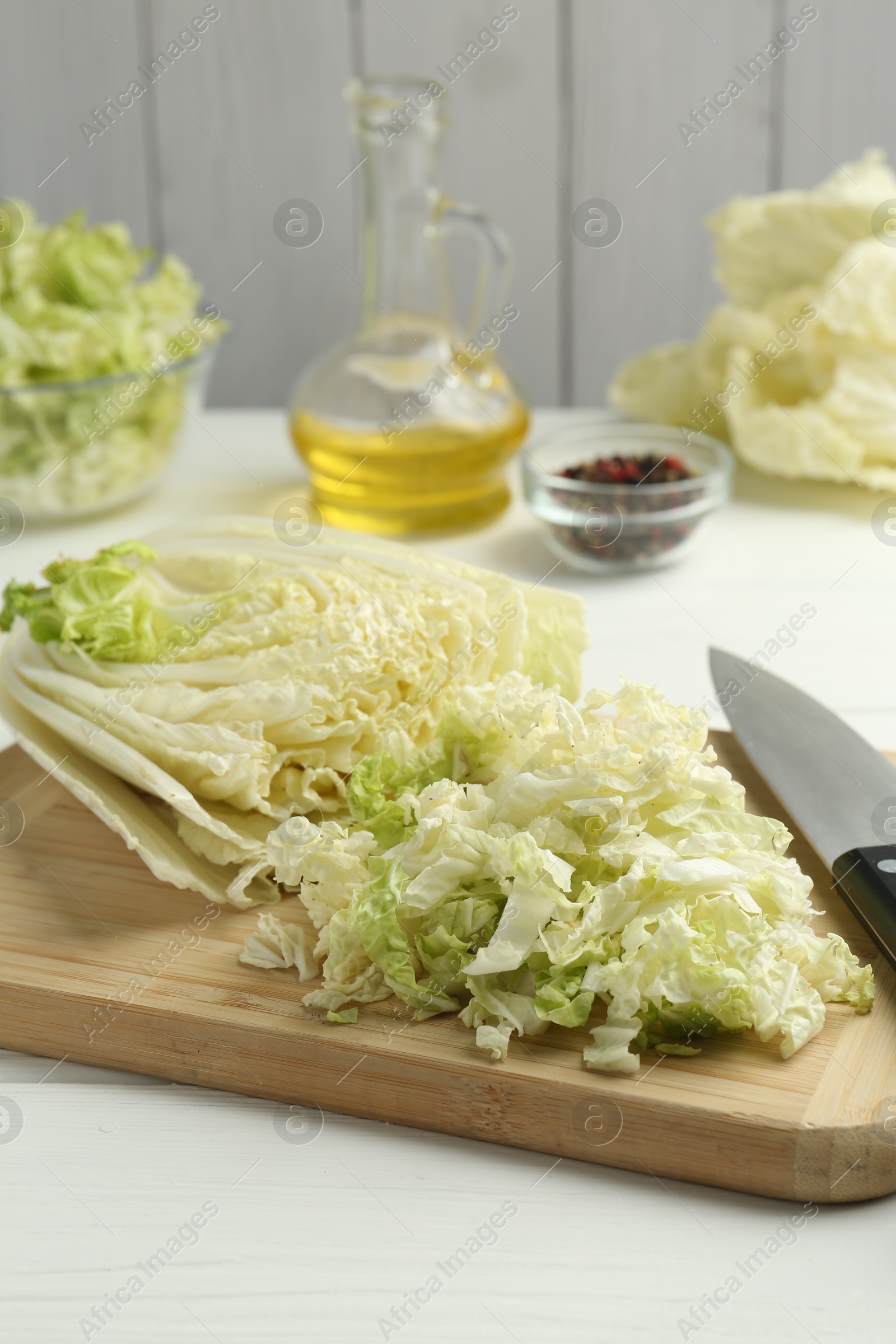 Cut Chinese cabbage and knife on white wooden table, closeup Photo of Cut Chinese cabbage and knife on white wooden table, closeup