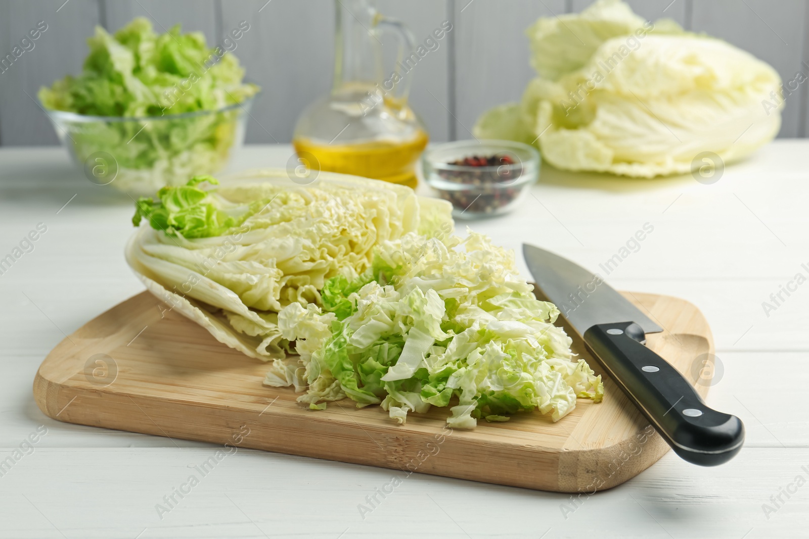 Cut Chinese cabbage and knife on white wooden table, closeup Photo of Cut Chinese cabbage and knife on white wooden table, closeup