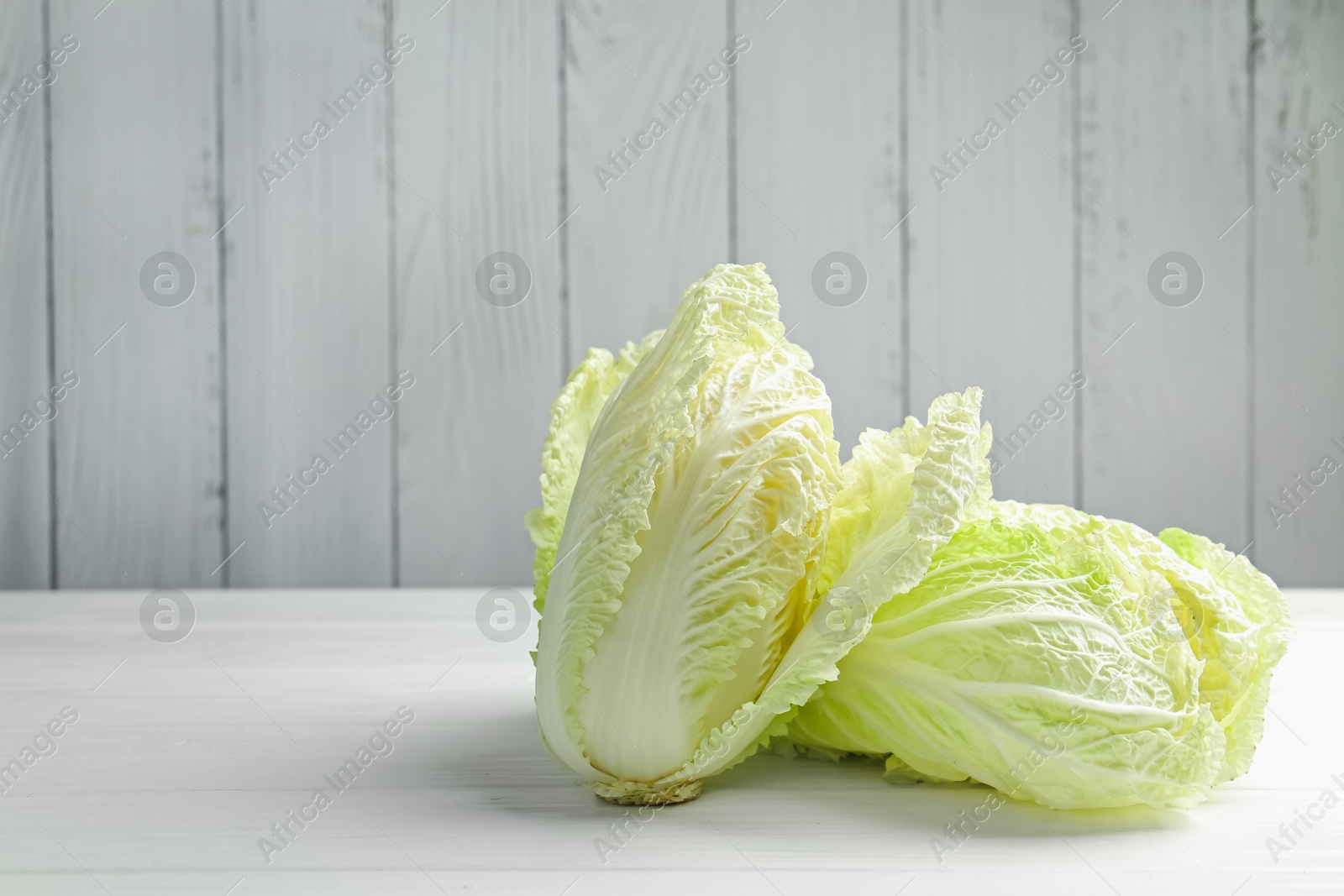 Fresh Chinese cabbages on white wooden table, closeup. Space for text Photo of Fresh Chinese cabbages on white wooden table, closeup. Space for text