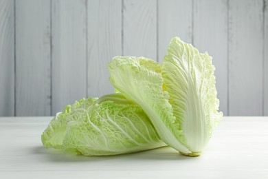 Photo of Fresh Chinese cabbages on white wooden table, closeup