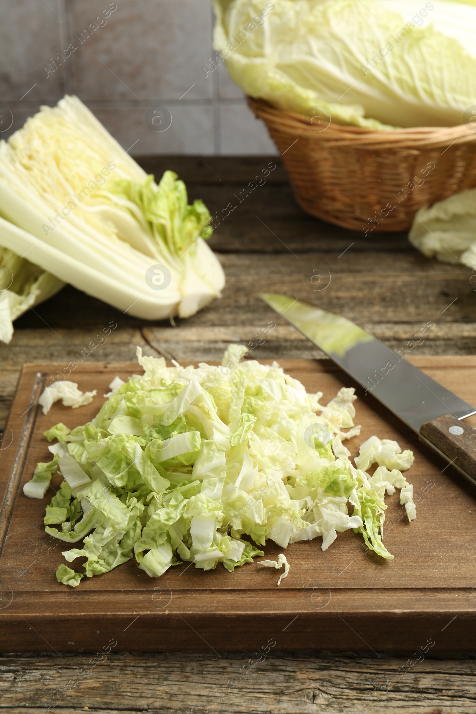 Cut Chinese cabbages and knife on wooden table, closeup Photo of Cut Chinese cabbages and knife on wooden table, closeup