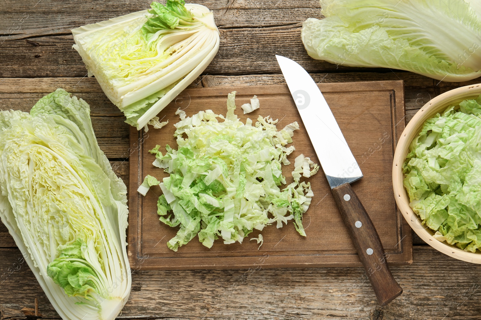 Cut Chinese cabbages and knife on wooden table, flat lay Photo of Cut Chinese cabbages and knife on wooden table, flat lay