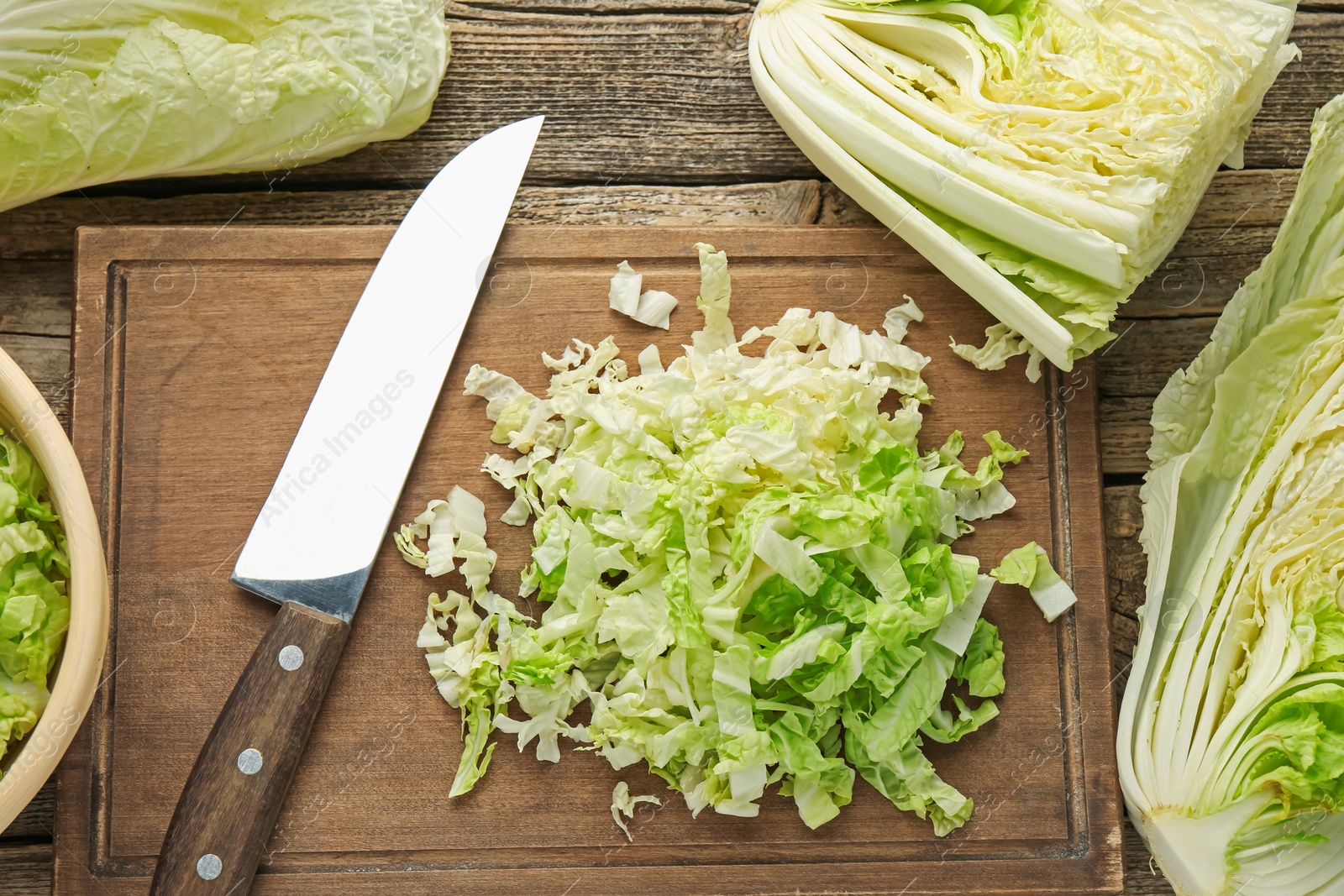 Cut Chinese cabbages and knife on wooden table, flat lay Photo of Cut Chinese cabbages and knife on wooden table, flat lay