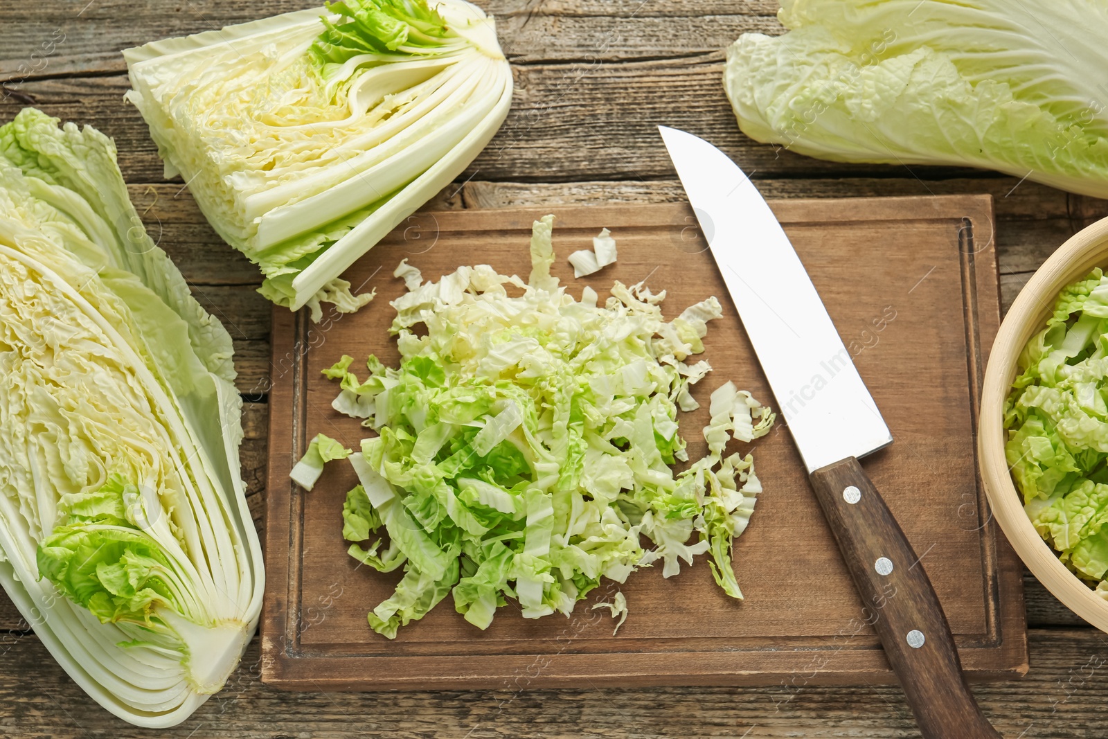 Cut Chinese cabbages and knife on wooden table, flat lay Photo of Cut Chinese cabbages and knife on wooden table, flat lay