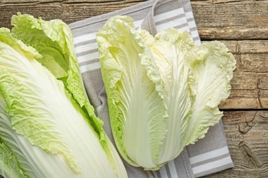 Photo of Fresh Chinese cabbages on wooden table, top view