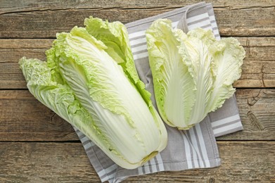 Photo of Fresh Chinese cabbages on wooden table, top view