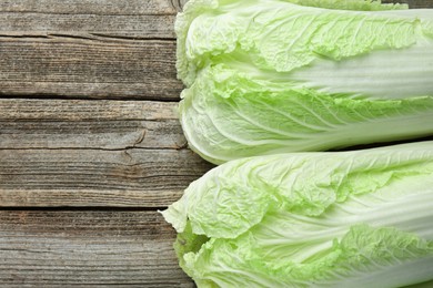 Photo of Fresh Chinese cabbages on wooden table, top view. Space for text