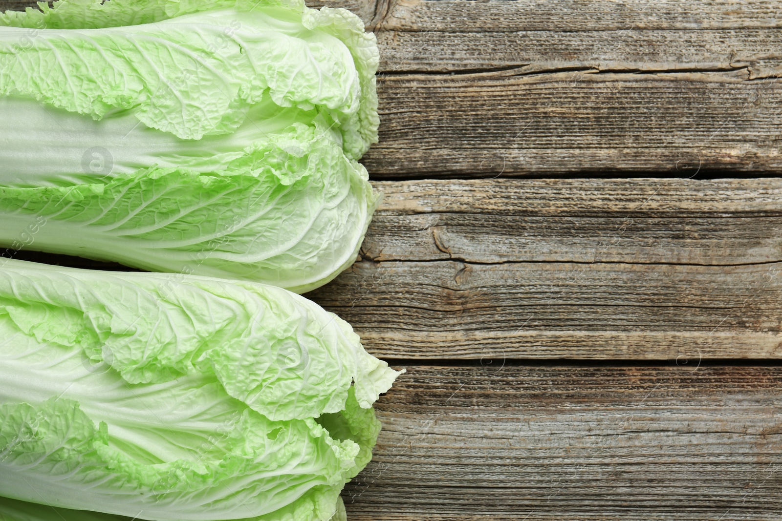 Fresh Chinese cabbages on wooden table, top view. Space for text Photo of Fresh Chinese cabbages on wooden table, top view. Space for text