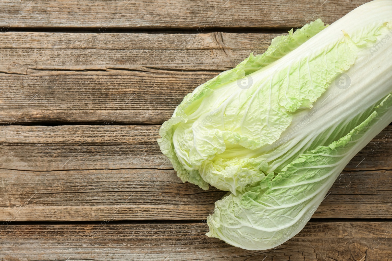 Fresh Chinese cabbage on wooden table, top view. Space for text Photo of Fresh Chinese cabbage on wooden table, top view. Space for text