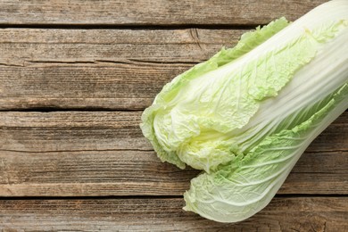 Photo of Fresh Chinese cabbage on wooden table, top view. Space for text