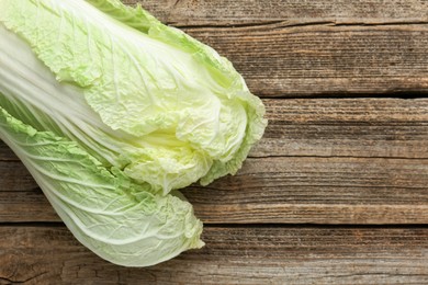 Photo of Fresh Chinese cabbage on wooden table, top view. Space for text
